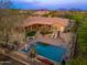 Backyard aerial view features a luxurious pool area, covered patio, and meticulous landscaping at 5712 E Blue Sky Dr, Scottsdale, AZ 85266