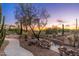 Backyard landscape featuring an elevated pool and mature trees with picturesque sunset views at 5712 E Blue Sky Dr, Scottsdale, AZ 85266