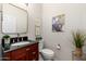 Powder room featuring a dark wooden vanity with dark stone countertop and decorative plants at 5712 E Blue Sky Dr, Scottsdale, AZ 85266