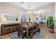Elegant dining room featuring a rustic wood table, bench seating, and modern chandelier at 5712 E Blue Sky Dr, Scottsdale, AZ 85266