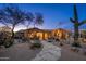 Charming single-story home with desert landscaping, a stone walkway and well-lit entryway at 5712 E Blue Sky Dr, Scottsdale, AZ 85266
