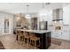 Large kitchen island with a marble countertop and barstool seating offers an open design to dining and living areas at 5712 E Blue Sky Dr, Scottsdale, AZ 85266