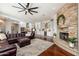 Spacious living room with stone fireplace, ceiling fan, and open flow to the modern kitchen at 5712 E Blue Sky Dr, Scottsdale, AZ 85266