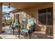 Relaxing covered patio featuring comfortable seating, a round table, and views of the desert landscape at 5712 E Blue Sky Dr, Scottsdale, AZ 85266