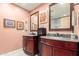 A luxurious bathroom with dual vanities, granite countertops, and decorative mirrors on pink walls at 6532 E Aster Dr, Scottsdale, AZ 85254