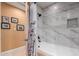An elegant bathroom featuring a soaking tub with marble tile surround and a rainfall shower head at 6532 E Aster Dr, Scottsdale, AZ 85254