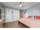 A cozy bedroom with an Arizona Wildcats pillow, ceiling fan, and two white closet doors at 6532 E Aster Dr, Scottsdale, AZ 85254