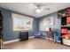 A modern bedroom with dark blue walls, light wood floors, a ceiling fan, and unique art at 6532 E Aster Dr, Scottsdale, AZ 85254