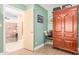 A hallway leading to rooms with light green and peach walls, showcasing a large armoire at 6532 E Aster Dr, Scottsdale, AZ 85254