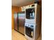 Laundry room featuring a stacked washer and dryer unit next to a modern, stainless steel refrigerator at 6532 E Aster Dr, Scottsdale, AZ 85254