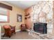 Cozy living area featuring a natural stone fireplace, comfortable seating, and a warm, inviting atmosphere at 6532 E Aster Dr, Scottsdale, AZ 85254