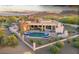 Backyard showcasing a private pool and spa, covered patio, built-in BBQ, and lush desert landscaping at 6551 E Flat Iron Loop, Gold Canyon, AZ 85118