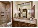 Bathroom with granite countertops, tiled shower with glass door, and wood-trimmed mirror at 6551 E Flat Iron Loop, Gold Canyon, AZ 85118