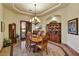 Elegant dining room features a tray ceiling, wood furnishings, marble flooring, and arched doorway at 6551 E Flat Iron Loop, Gold Canyon, AZ 85118