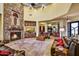 Large living room with stone fireplace, comfortable seating and exterior landscape views at 6551 E Flat Iron Loop, Gold Canyon, AZ 85118