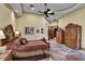 Comfortable bedroom with decorative ceiling fan, wood furniture and arched doorway to closet and bathroom at 6551 E Flat Iron Loop, Gold Canyon, AZ 85118