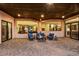 A covered patio with comfortable seating and views into the home's interior through large windows and sliding glass doors at 6551 E Flat Iron Loop, Gold Canyon, AZ 85118