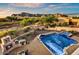 Wide view of pool, outdoor kitchen, desert vegetation, and mountain views in distance at 6551 E Flat Iron Loop, Gold Canyon, AZ 85118