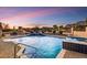 Backyard swimming pool and spa with an outdoor kitchen and barbecue at sunset at 6551 E Flat Iron Loop, Gold Canyon, AZ 85118