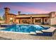 A stunning backyard pool and spa with stone accents and tiling, surrounded by a brick patio and a luxurious home at 6551 E Flat Iron Loop, Gold Canyon, AZ 85118