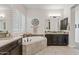 This bathroom features dual sinks, a soaking tub, designer tile, and plantation shutters at 6706 S Jacqueline Way, Gilbert, AZ 85298