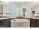 Bathroom featuring a soaking tub with tile surround, dark cabinetry and dual sinks at 6706 S Jacqueline Way, Gilbert, AZ 85298