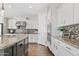 Well-lit kitchen boasts granite countertops, a mosaic backsplash, and built-in stainless steel appliances at 6706 S Jacqueline Way, Gilbert, AZ 85298