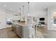 Bright kitchen with gray island, granite countertops, mosaic backsplash, and stainless steel appliances at 6706 S Jacqueline Way, Gilbert, AZ 85298