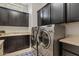 Spacious laundry room with dark cabinets and stainless steel appliances at 6706 S Jacqueline Way, Gilbert, AZ 85298