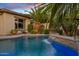 Inviting pool with a tranquil waterfall feature, complemented by lush greenery and ambient landscape lighting at 6706 S Jacqueline Way, Gilbert, AZ 85298