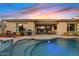 Gorgeous pool and patio area featuring an outdoor kitchen, seating and views of the beautifully lit pool at 6706 S Jacqueline Way, Gilbert, AZ 85298