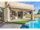 Covered patio overlooking a sparkling pool, spa, and artificial turf, offering a luxurious outdoor retreat at 7439 E Beryl Ave, Scottsdale, AZ 85258