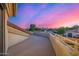 Exterior balcony view showcasing the vibrant sunset, neighboring houses, and lush greenery at 7439 E Beryl Ave, Scottsdale, AZ 85258
