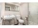 Bathroom with a large framed mirror, white toilet, and shower with white tile and glass door at 7439 E Beryl Ave, Scottsdale, AZ 85258