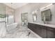 Modern bathroom with marble floor, bathtub, dual vanity sinks and decorative lighting at 7439 E Beryl Ave, Scottsdale, AZ 85258