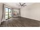 Bright bedroom with wood floors, a ceiling fan, and large windows overlooking the backyard pool at 7439 E Beryl Ave, Scottsdale, AZ 85258
