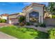 Beautiful exterior view of this home with a well-manicured lawn, lush plants, and a two-car garage at 7439 E Beryl Ave, Scottsdale, AZ 85258