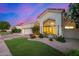 Charming home exterior with a well-maintained lawn, desert landscaping, and a beautiful sunset sky in the background at 7439 E Beryl Ave, Scottsdale, AZ 85258