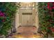 Elegant entryway featuring double doors framed by lush bougainvillea and stylish outdoor lighting at 7439 E Beryl Ave, Scottsdale, AZ 85258
