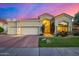 Charming home with well-maintained landscaping, a three car garage, and a tile roof at sunset at 7439 E Beryl Ave, Scottsdale, AZ 85258