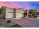 Exterior view of a home's three car garage with a driveway and manicured lawn at 7439 E Beryl Ave, Scottsdale, AZ 85258