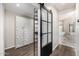 Hallway with sliding barn door leading into bathroom with marble floor and bathtub at 7439 E Beryl Ave, Scottsdale, AZ 85258