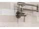 A close up of a faucet featuring brushed silver finish and a clean white tile backsplash at 7439 E Beryl Ave, Scottsdale, AZ 85258