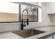 Close-up of a modern kitchen sink with a stylish faucet and a bright window above at 7439 E Beryl Ave, Scottsdale, AZ 85258