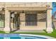 Covered patio next to the pool with artificial grass and stylish outdoor seating at 7439 E Beryl Ave, Scottsdale, AZ 85258