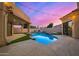 Inviting backyard pool and spa with colorful sunset backdrop and string lights at 7439 E Beryl Ave, Scottsdale, AZ 85258