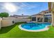 Stunning backyard featuring a sparkling pool, spa, and artificial turf, perfect for outdoor relaxation and entertainment at 7439 E Beryl Ave, Scottsdale, AZ 85258