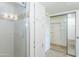 Bathroom featuring a glass-door shower, white cabinets, and mirrored closet doors at 7970 E Camelback Rd # 604, Scottsdale, AZ 85251