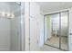 Bathroom featuring a glass-door shower, white cabinets, toilet, and mirrored closet doors at 7970 E Camelback Rd # 604, Scottsdale, AZ 85251