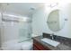 Bathroom with granite vanity, round mirror, and shower-tub combo with a sliding glass door at 7970 E Camelback Rd # 604, Scottsdale, AZ 85251
